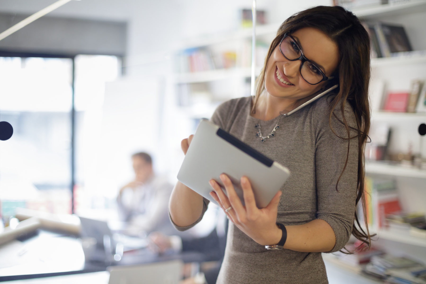 How to Become a Personal Assistant (PA or EA) - Businesswoman talking on phone and uses digital tablet 